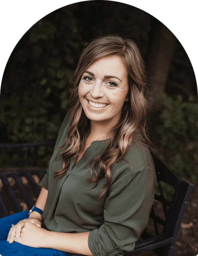 Smiling woman sitting on a bench outside.